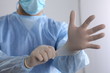 Male doctor putting on disposable gloves