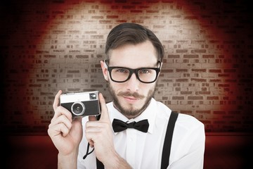 Poster - Composite image of geeky hipster holding a retro camera