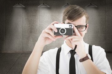 Poster - Composite image of geeky hipster holding a retro camera