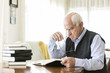 © photopitu - Senior man reading book relaxed at home