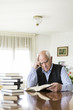 © photopitu - Senior man reading book relaxed at home