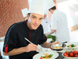 © goodluz - Chef in restaurant kitchen preparing dish