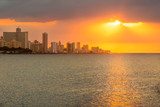 Fototapeta Miasta - Beautiful sunset in Havana with the sun shining on the sea