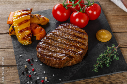 Photographie Steak grillé de boeuf avec des légumes sur une surface en bois