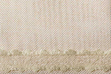 Wall Mural - Lace ribbon on sack cloth background