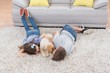 © WavebreakMediaMicro - Siblings with dog lying on rug