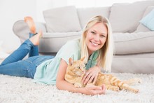 Happy Woman With Cat Lying On Rug