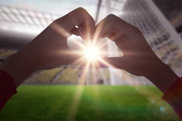 Poster - Composite image of woman making heart shape with hands