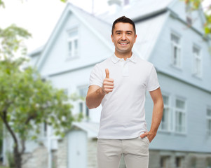 Poster - man showing thumbs up over house background