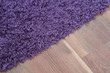 © cobracz - Purple shaggy carpet on brown wooden floor