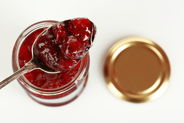 Wall Mural - Jar of strawberry jam with spoon isolated on white