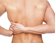 © cristovao31 - Rear view of a young man holding his back in pain, isolated on w