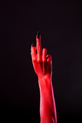 Wall Mural - Red devil hand with black nails showing middle finger