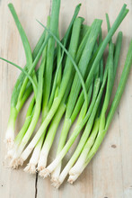 Green Onions Isolated On Wooden Background