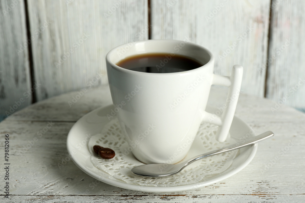 Cup of coffee with beans on color rustic wooden background