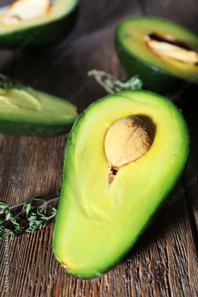 Sliced avocado with herb on wooden background