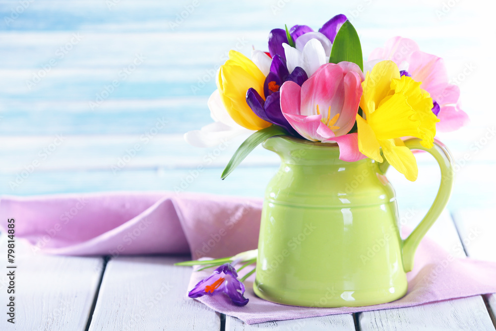 Beautiful spring flowers on wooden table on blue background