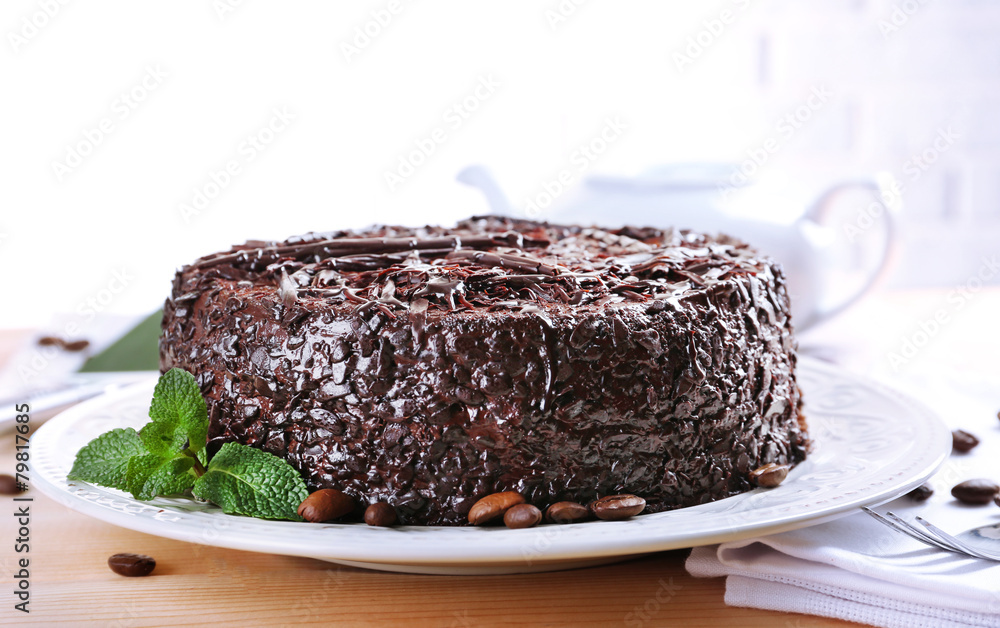 Tasty chocolate cake on table on brick wall background