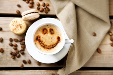 Cup of coffee  and macaroons on old wooden table