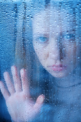 Poster - melancholy and sad young  woman  at the window in the rain