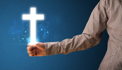 Wall Mural - Glowing cross in the hand of a businessman