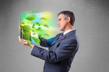 Wall Mural - Businessman holding laptop with recycle and environmental symbo