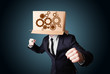 Businessman gesturing with a cardboard box on his head with spur