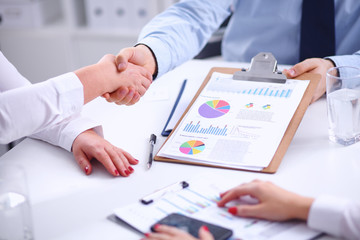 Business people handshake, sitting at the table