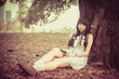 © 9'63 Creation - A cute Asian Thai girl is leaning on a tree trunk sleeping while
