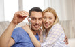 © Syda Productions - smiling couple showing keys over room background