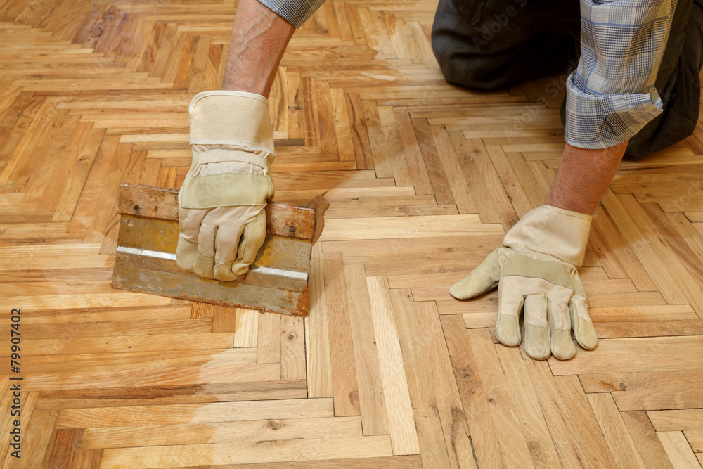 Varnishing of oak parquet floor, workers hand and tool - obrazy, fototapety, plakaty 