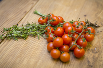 Tomaten/Strauchtomaten und Rosmarin auf Tischplatte