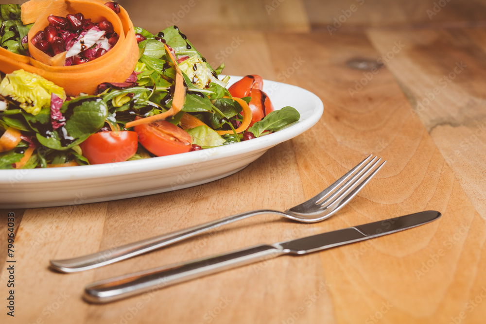 Stock-Foto „Salat auf kleinem Teller mit Messer und Gabel“ | Adobe Stock