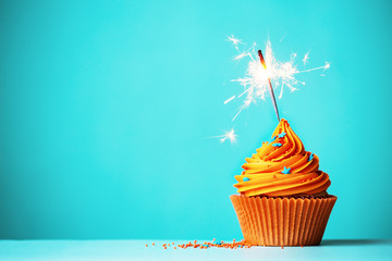 Wall Mural - Orange cupcake with sparkler