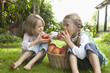 © Westend61 - Germany, Bavaria, Munich, Girls eating apple in garden