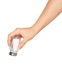 Hand Holding A Glass Saltcellar With Salt Isolated On A White Ba