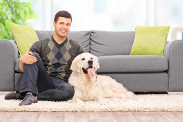 Poster - Young man sitting on the floor with his dog