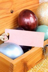 Wall Mural - Colorful easter egg in wood box with paper tag.