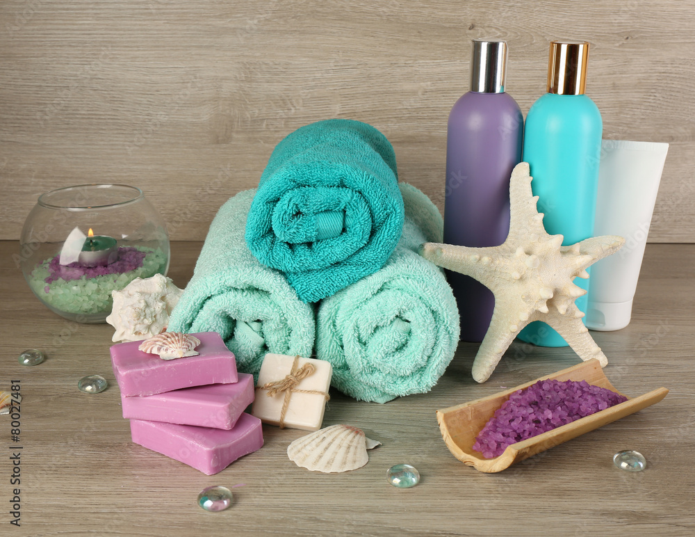 Spa composition with towels and sea salt on wooden background