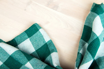 green folded tablecloth over bleached wooden table