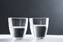 Two Glasses Of Water On Table On Dark Background