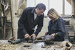 © Mr.X - Two artists examining a sculpture in a workshop
