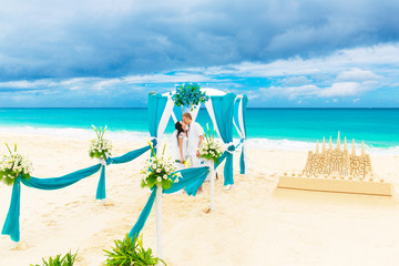 Wedding ceremony on a tropical beach in blue. Happy groom and br