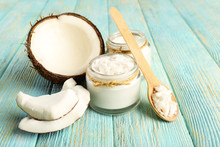 Fresh Coconut Oil In Glassware And Wooden Spoon