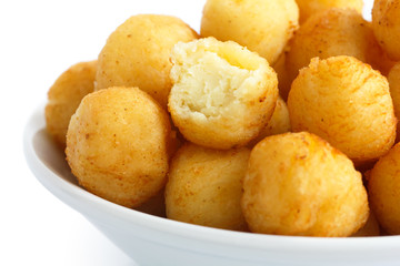 Wall Mural - Bowl of fried small potato balls on white.