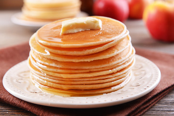 Wall Mural - Delicious pancakes with honey on plate on table close-up