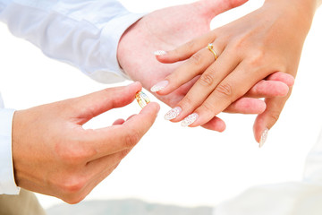 Groom giving an engagement ring to his bride under the arch deco