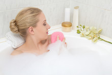 Woman Relaxing In Bath And Washing Herself By Sponge