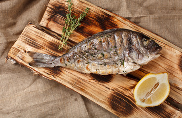 grilled fish on logs with lemon and herbs asia