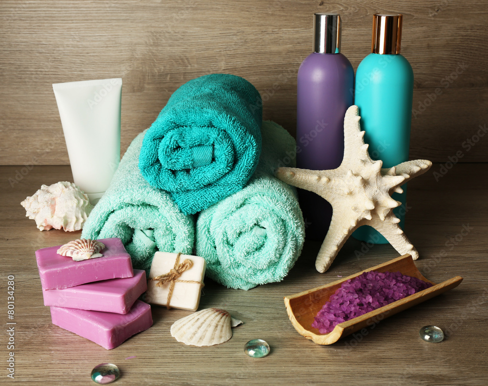 Spa composition with towels and sea salt on wooden background